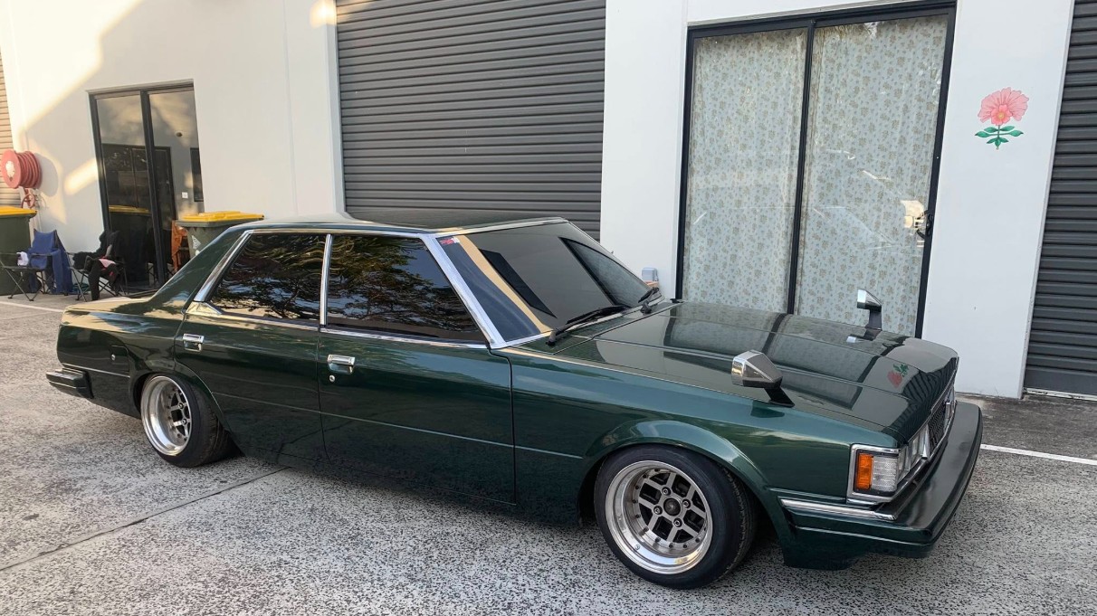 Dark green sedan with premium tint and chrome trim